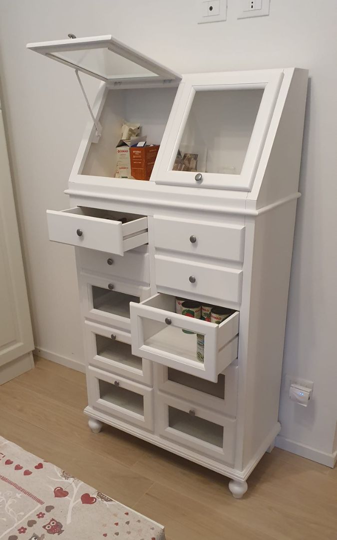 Dispensa bianca stile arte povera con cassetti e ante in vetro, organizzazione cucina.